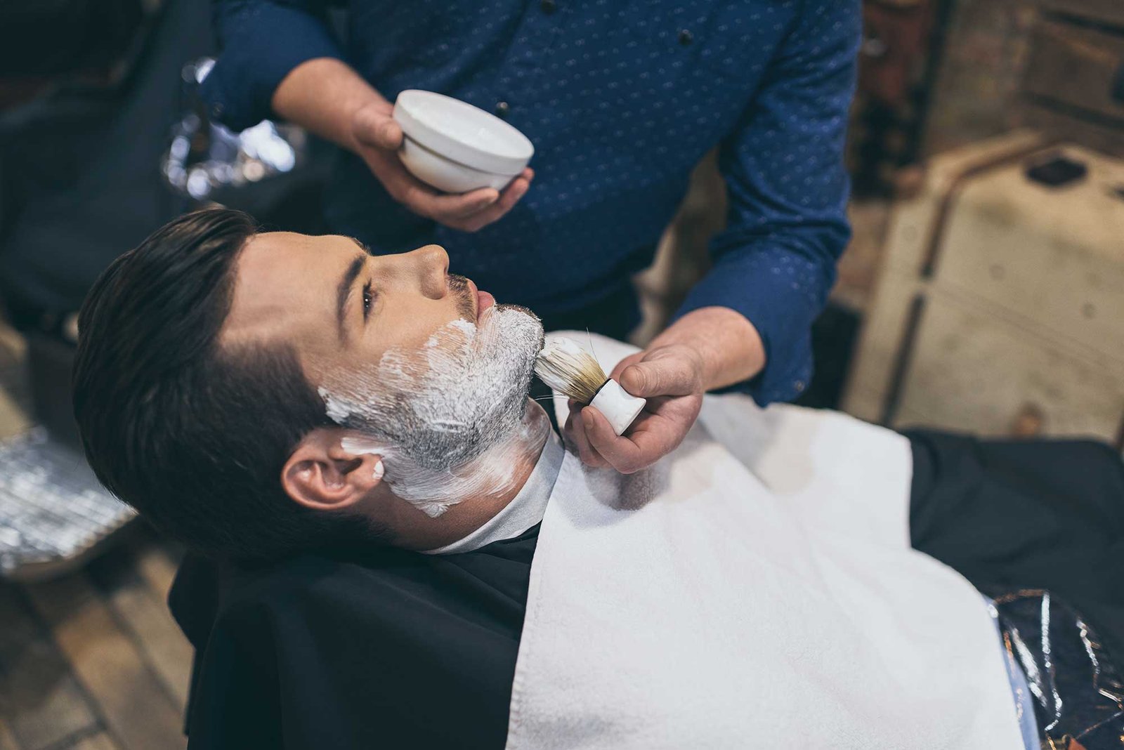 barber-applying-foam-before-shaving-of-customer-in-2022-12-16-17-03-17-utc-2.jpg